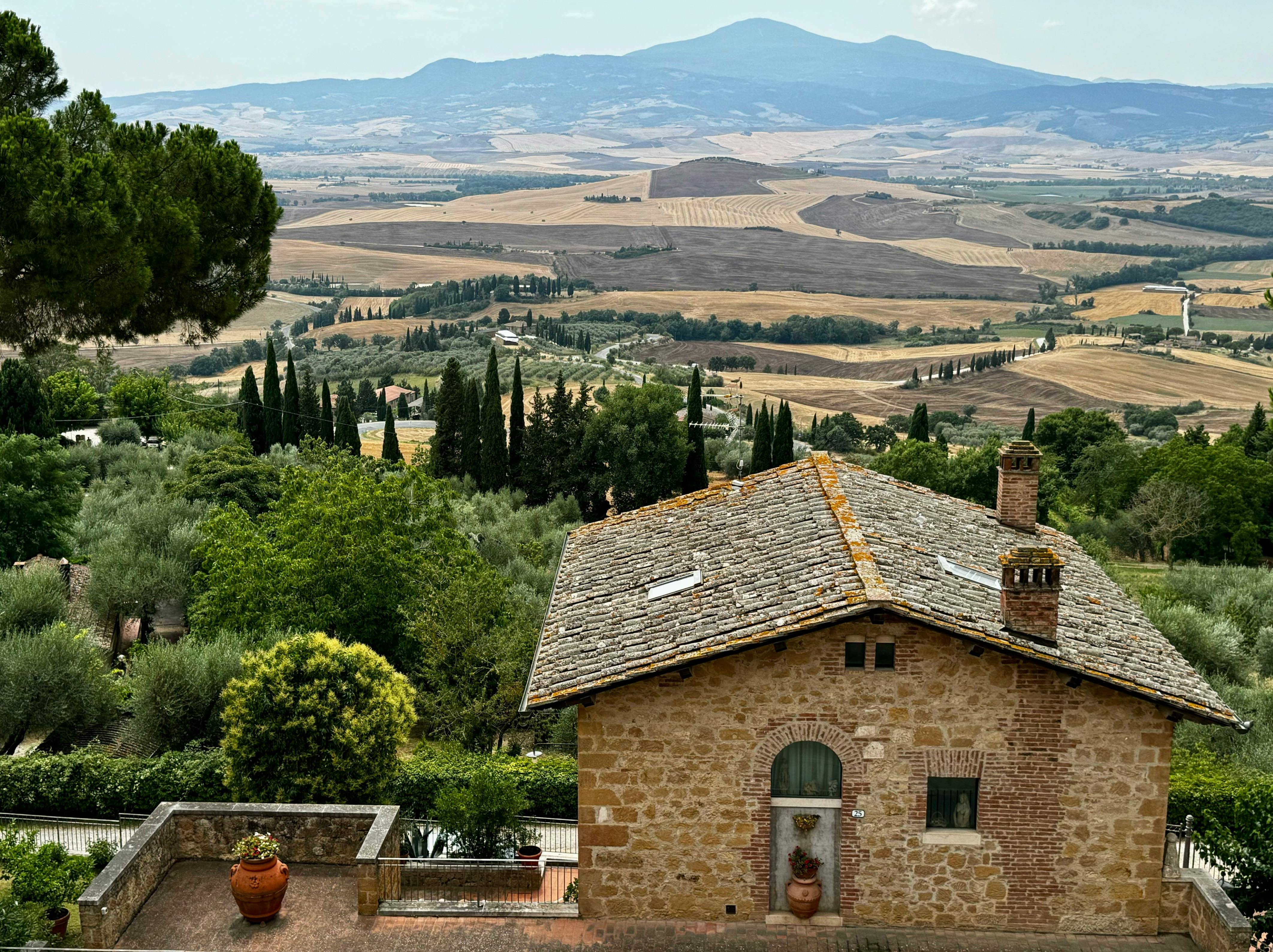 Esterno di un agriturismo italiano tradizionale con giardino e paesaggio rurale