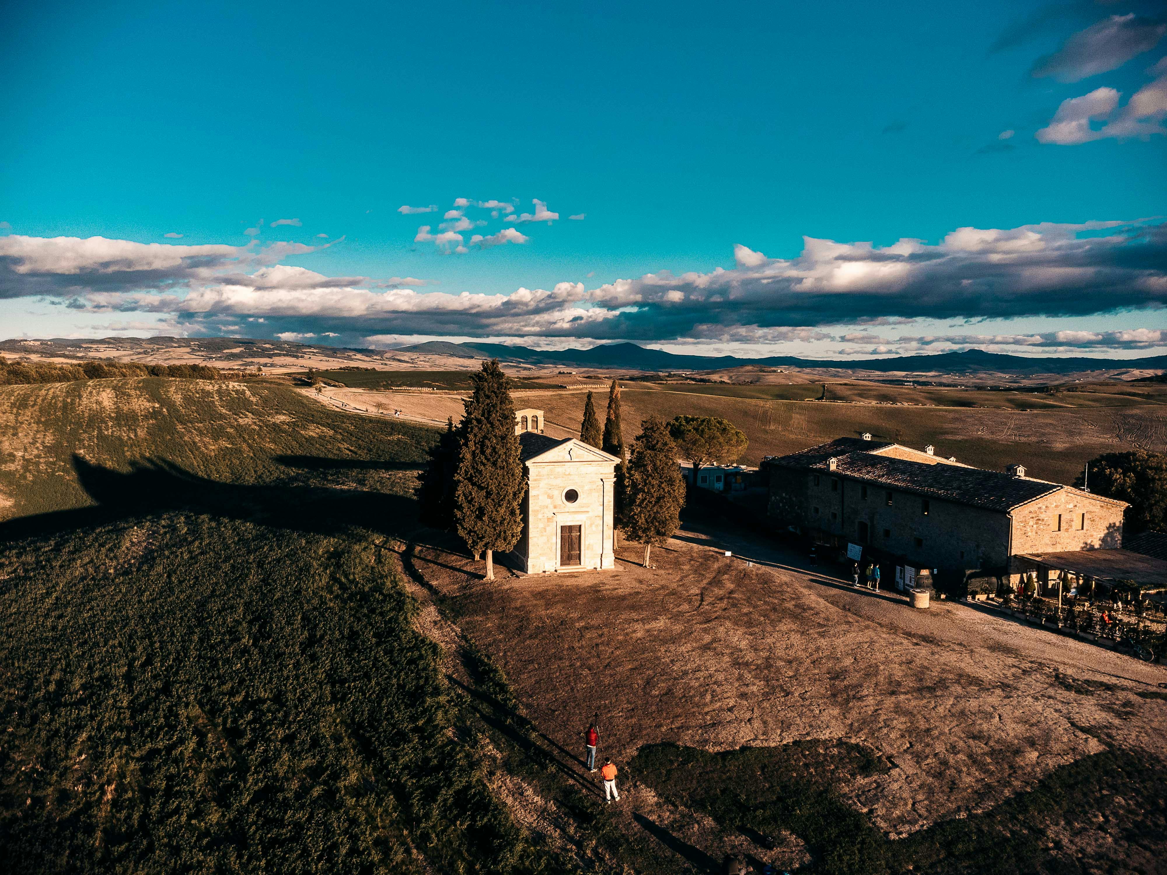 Strada tra i vigneti del Chianti e borgo in pietra nella luce estiva